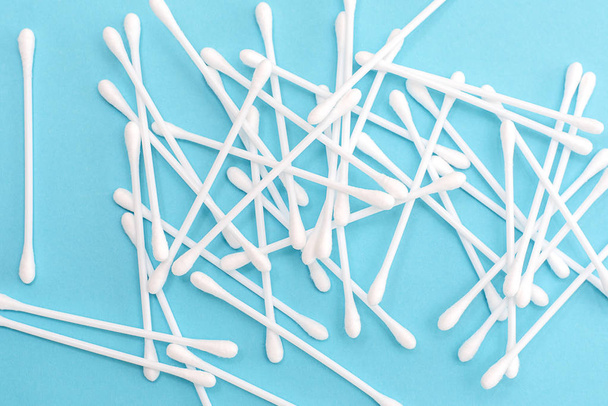 White cotton buds scattered on blue background - Photo, Image