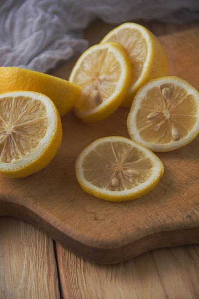 Sliced lemon on a wooden plate.Fresh juicy sliced lemon.Rustic m - Photo, Image