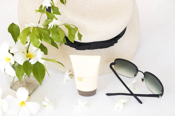 natuurlijke cosmetica zonnebrandcrème SPF50 gezondheidszorg huid gezicht met zonnebril, hoed van lifestyle vrouw ontspannen zomer arrangement plat lay stijl op achtergrond wit  - Foto, afbeelding
