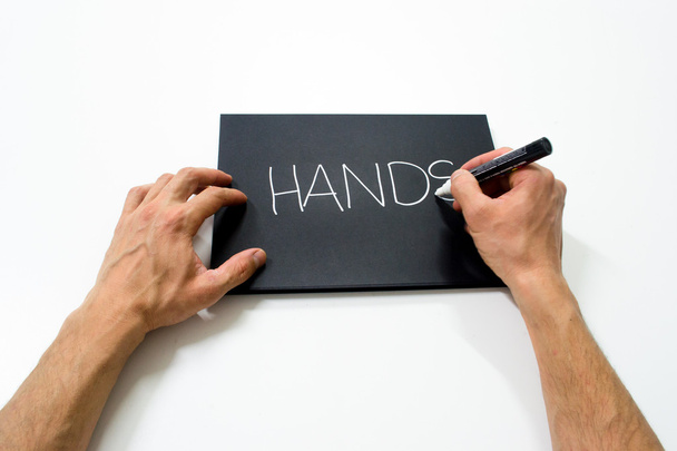 дві руки пишуть "руки" на чорному тлі
 - Фото, зображення