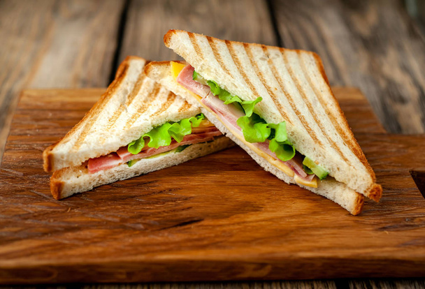 Sandwiches a la parrilla caseros frescos en tablero de madera
 - Foto, Imagen