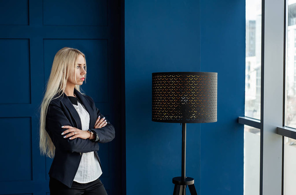 Elegante zakenvrouw poseren in stijlvolle blauwe studio  - Foto, afbeelding