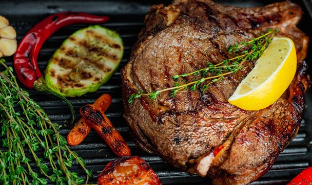Fresh grilled pork steak with rosemary and vegetables in grilling pan  - Photo, Image
