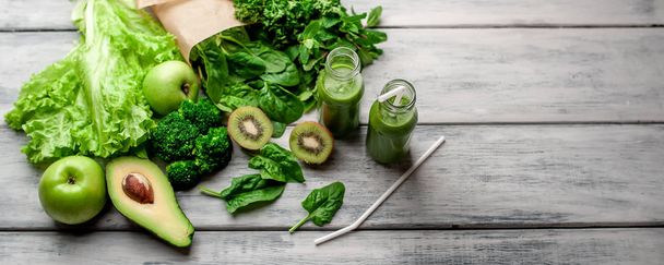 Tuore vihreä smoothie vihanneksilla ja hedelmillä harmaalla taustalla
 - Valokuva, kuva