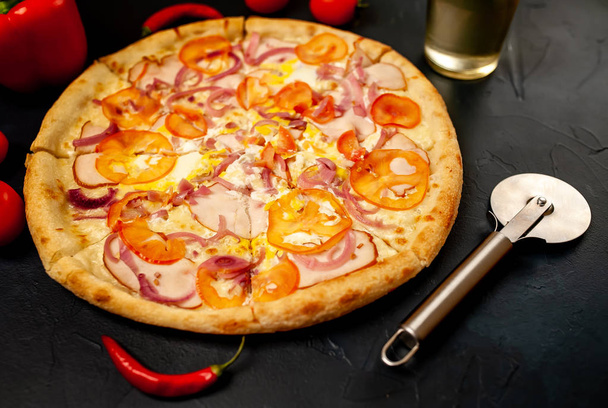 Pizza aux légumes frais avec jambon sur fond de pierre noire
 - Photo, image