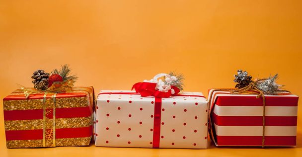 Stapel von Geschenkboxen mit roten Schleifen auf leuchtend gelbem Hintergrund  - Foto, Bild