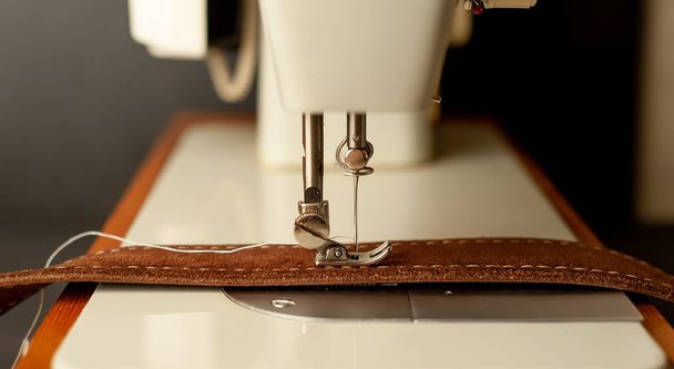 茶色の革ベルトを縫うミシンの近い眺め  - 写真・画像