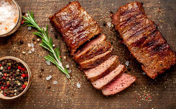 pečené vepřové steaky s kořením a Rosemary na dřevěné sekací desce  - Fotografie, Obrázek