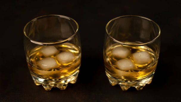 Un par de vasos con whisky helado sobre fondo negro
 - Foto, imagen