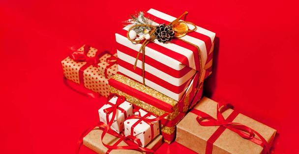 Pile de boîtes-cadeaux avec des arcs rouges sur fond rouge vif
  - Photo, image