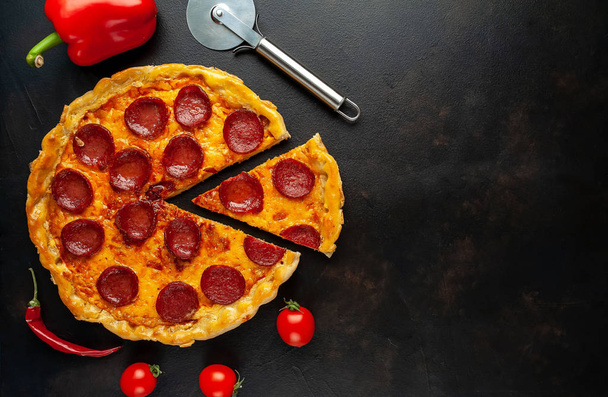 Tradizionale gustosa pizza con salame piccante su fondo pietra
 - Foto, immagini
