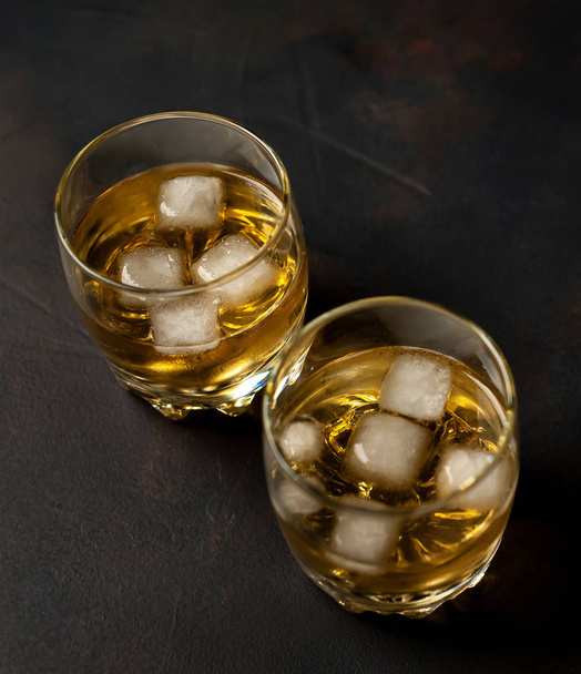 Couple of glasses with ice whiskey on black background - Valokuva, kuva
