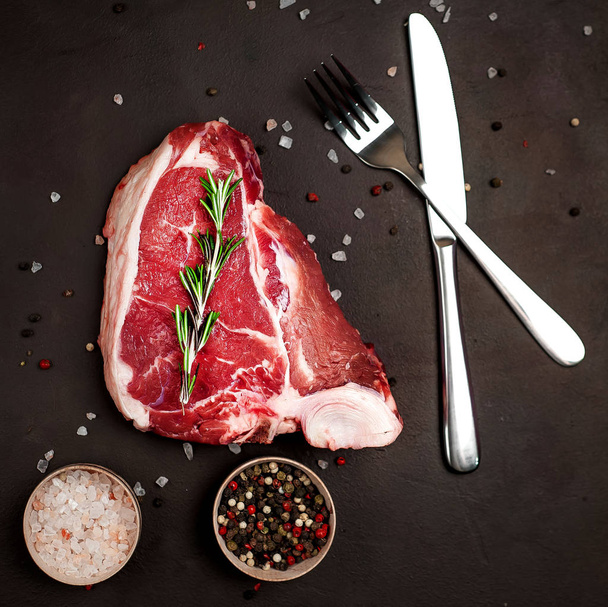 Taş arka planda baharat ve biberiye dal ile Çiğ yağ biftek - Fotoğraf, Görsel
