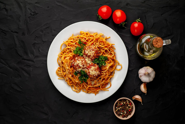 italian spaghetti pasta with meatballs, parmesan cheese and parsley twigs in white plate - Foto, immagini