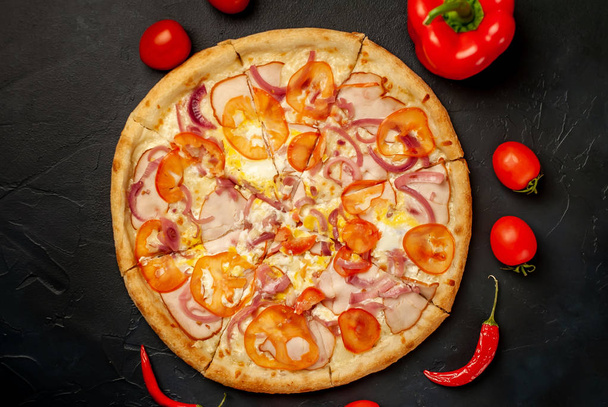 Fresh vegetable pizza with ham on black stone background - Foto, immagini