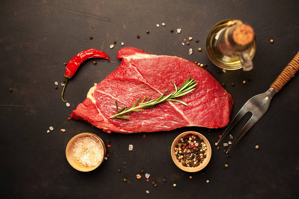 Steak de bœuf cru aux épices et romarin sur fond de pierre
 - Photo, image
