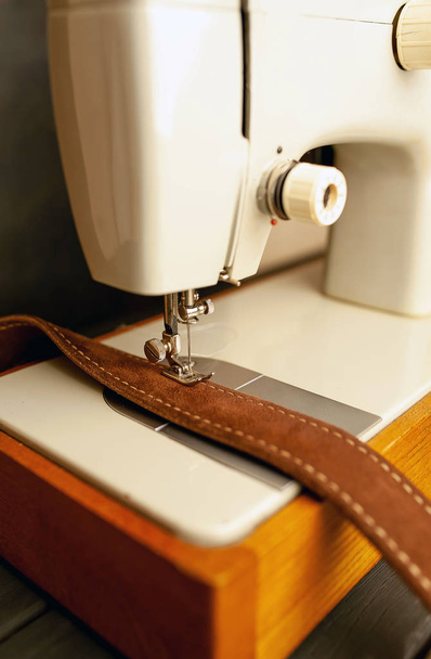 Vista próxima da máquina de costura de costura cinto de couro marrom
  - Foto, Imagem