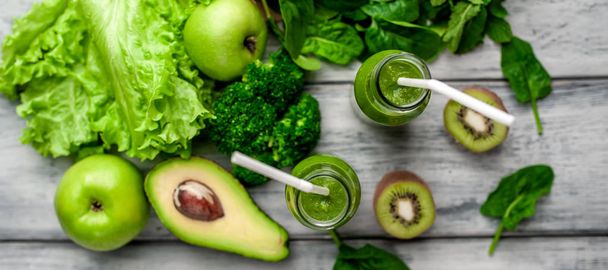 Fresh green smoothie with vegetables and fruits on grey background - 写真・画像