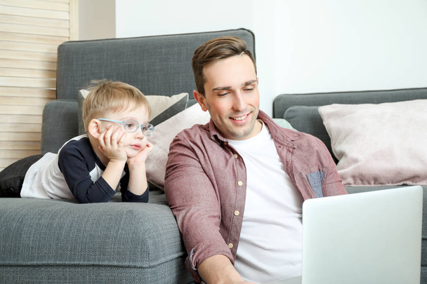Jeune père avec petit fils regardant des dessins animés à la maison
 - Photo, image
