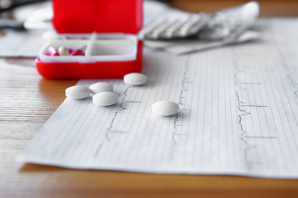 Cardiogram and pills on table in clinic, closeup - Photo, Image
