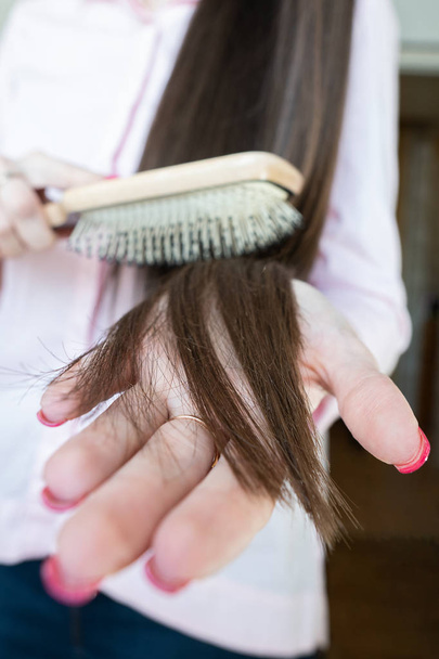 Pembe gömlekli esmer kız onu güzel uzun saç tarak tarama olduğunu - Fotoğraf, Görsel