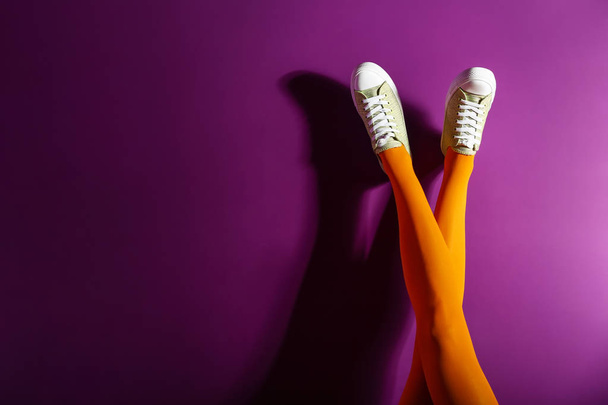 Junge Frau in stilvollen Schuhen auf farbigem Hintergrund - Foto, Bild