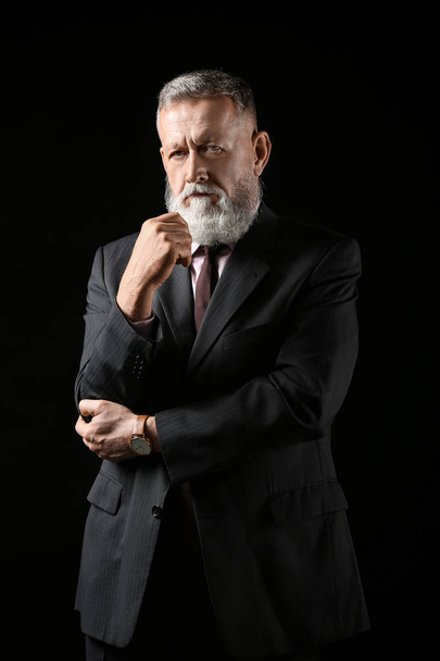 Handsome mature businessman on dark background - Photo, image