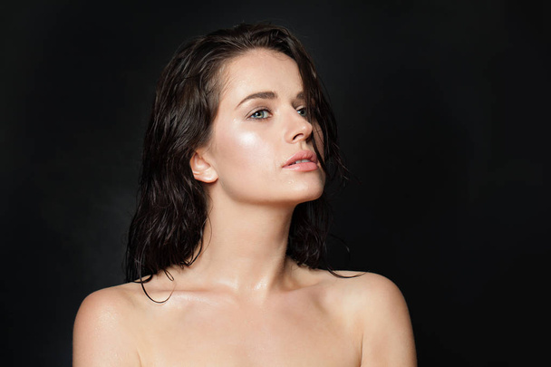Portrait of cute woman with wet skin and hair on black background - Photo, Image
