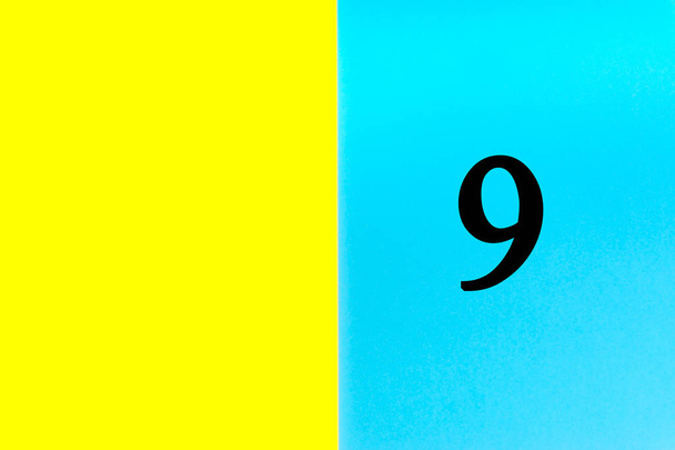 Εννέα ή 9 γραμμένες λέξεις σε μπλε και κίτρινο φόντο. Έννοια αριθμός, ημερολόγιο, μήνας, ημερομηνία και αντιγραφή χώρου - Φωτογραφία, εικόνα