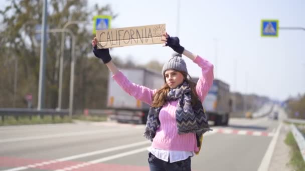 Jovem mulher bonita carona parando carro com cartaz Califórnia
 - Filmagem, Vídeo