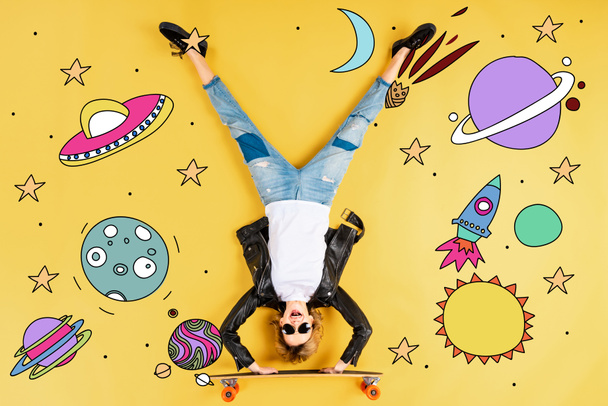 top view of woman in leather jacket standing on hands on longboard on yellow background with space illustration - Photo, Image