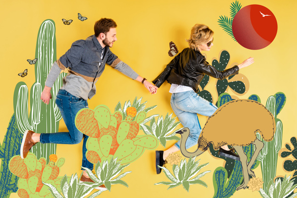 top view of woman holding hands with boyfriend while lying on yellow background with cacti and ostrich illustration - 写真・画像