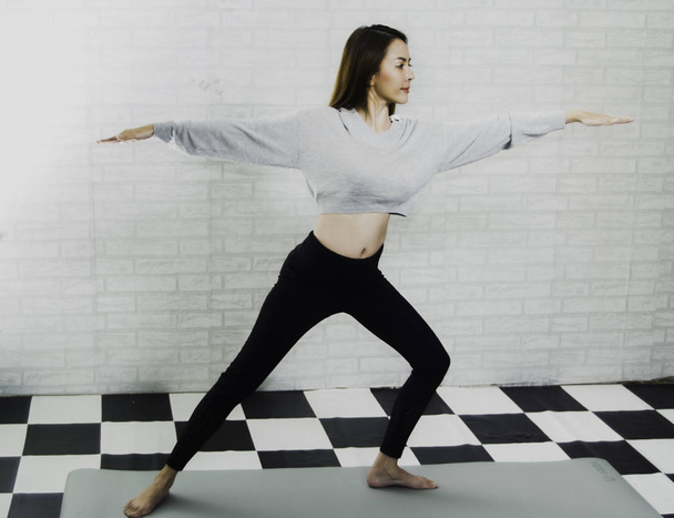 Mooie Aziatische meisje trainer, onderwijs yoga post op schuim, met w - Foto, afbeelding