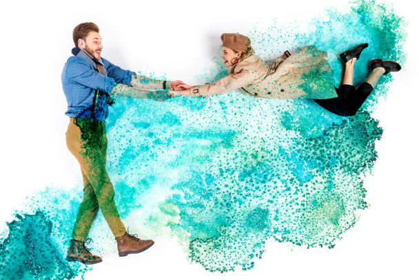 elegant woman levitating in air and holding hands with man on background with watercolor turquoise spills - Photo, Image