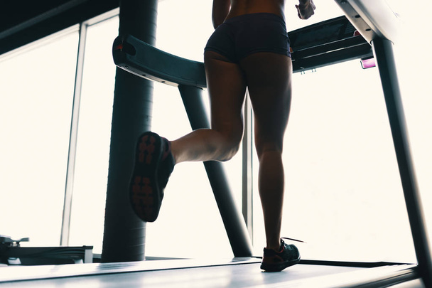 Early morning sport, female legs running on the gym treadmill early morning - Fotoğraf, Görsel
