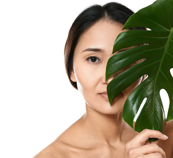 Femme asiatique avec feuille tropicale sur fond blanc
 - Photo, image