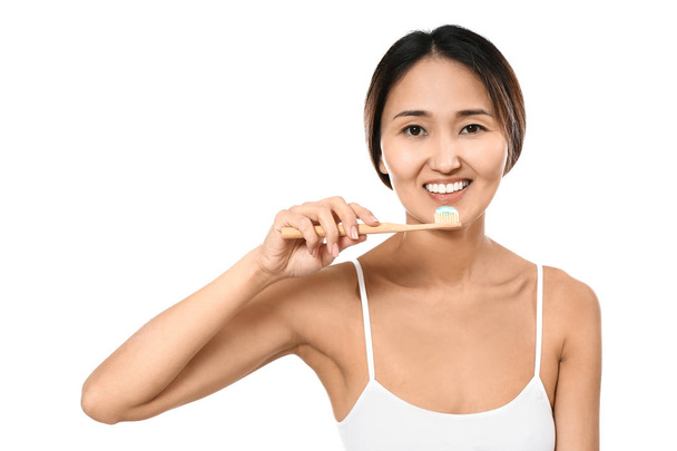 Femme asiatique brossant les dents sur fond blanc
 - Photo, image
