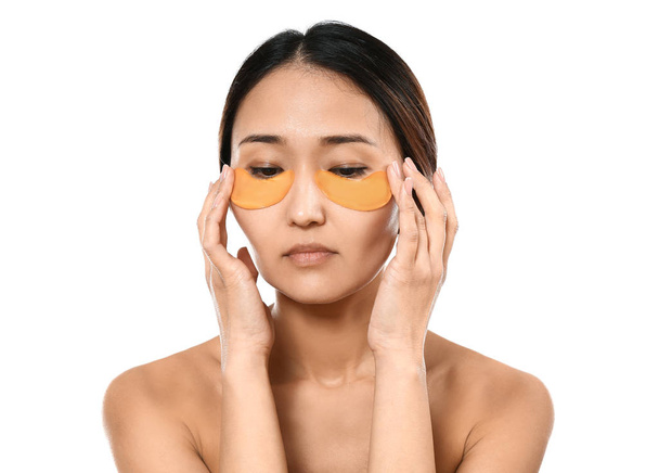 Asian woman with under-eye patches on white background - Fotoğraf, Görsel