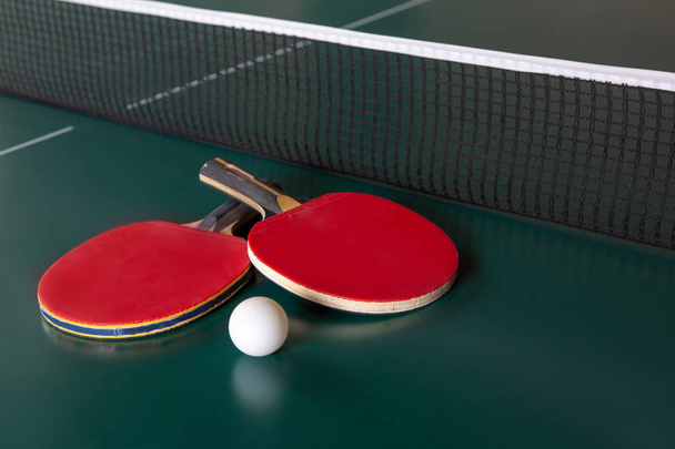 Two ping-pong rackets and a ball on a green table. Close-up - Fotoğraf, Görsel