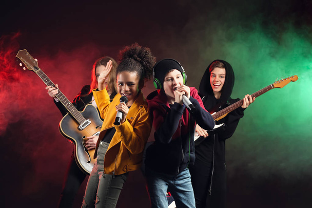 Band of teenage musicians on dark background - Foto, immagini
