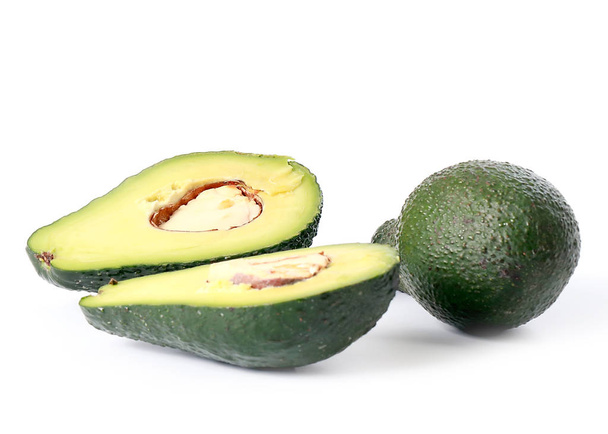halved seeds and whole tropical avocado fruit - Φωτογραφία, εικόνα