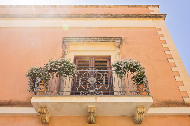 Low angle view of the terracotta facade with cozy balcony - Foto, imagen