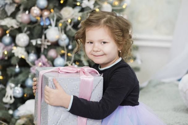 Happy little girl with Christmas gift. Girl delighted with gift. - Фото, зображення