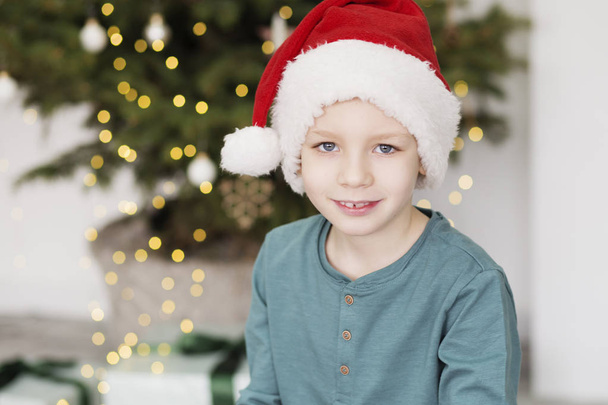 Chlapeček v Santa klobouku. Portrét krásného kluka na Vánoce  - Fotografie, Obrázek