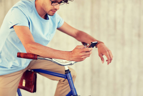 man with smartphone and fixed gear bike on street - Zdjęcie, obraz