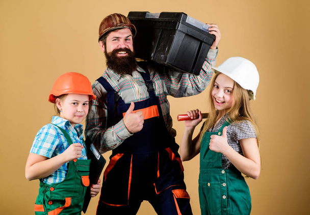 Father and daughter in workshop. Bearded man with little girls. Family teamwork. Industry. Tools for repair. engineering education. construction worker assistant. Repairman in uniform. Work is done - Фото, изображение