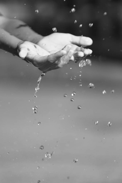 Νερό που χύνεται στα χέρια του παιδιού - Φωτογραφία, εικόνα