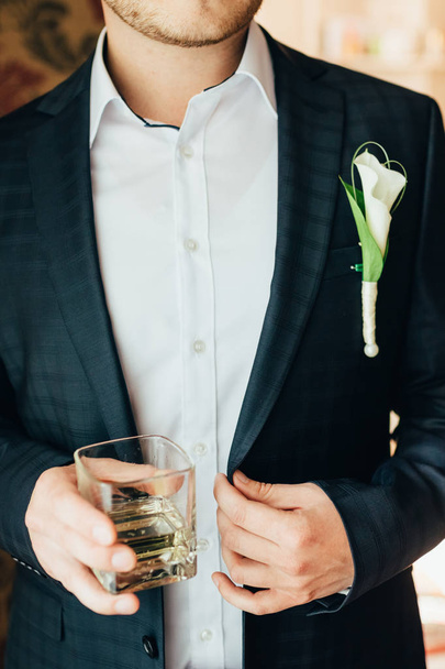groom holds a glass of whiskey - Foto, Imagen