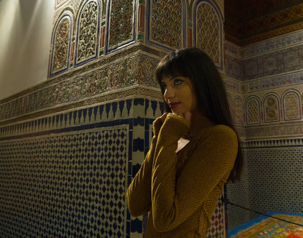 Beautiful Moroccan Girl in Short Golden Dress in Rich Mosaic interior of Picturesque Dar Si Said Riyad in Marrakech - Photo, Image