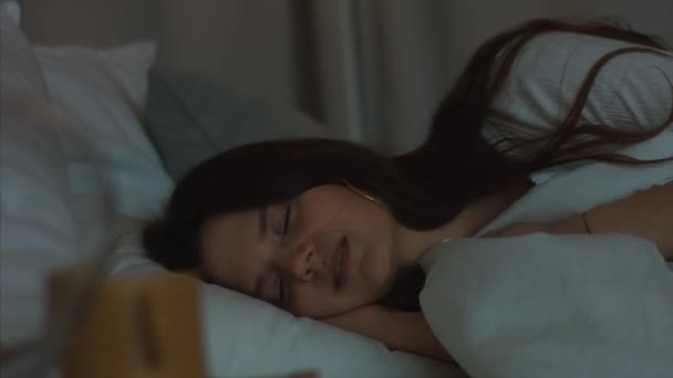 Väsynyt nainen nukahtaa sängylle lähikuva naisen kasvot 4k yö kasvojen kosmetiikka. Väsynyt tyttö nukkuu silmät kiinni valkoisissa vaatteissa pyjamassa. Naisten kauneus teollisuuden terveiden elämäntapojen
 - Materiaali, video